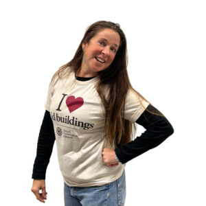 A woman smiling and wearing a shirt that says “I love old buildings” with the Duluth Preservation Alliance logo.